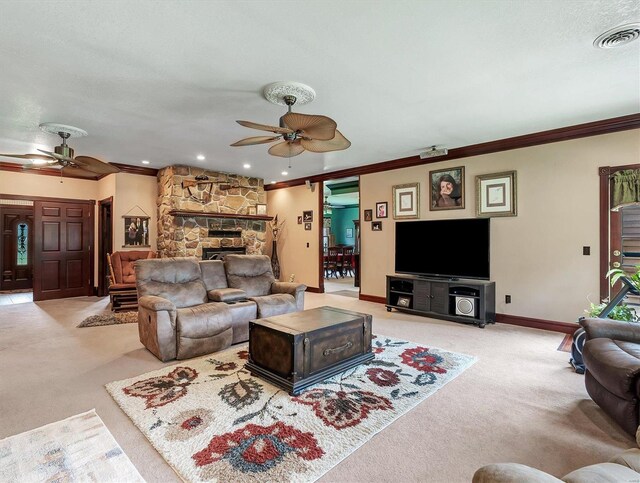 carpeted living room with crown molding, ceiling fan, and a fireplace