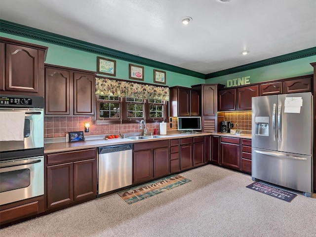 kitchen with dark brown cabinetry, sink, crown molding, stainless steel appliances, and backsplash