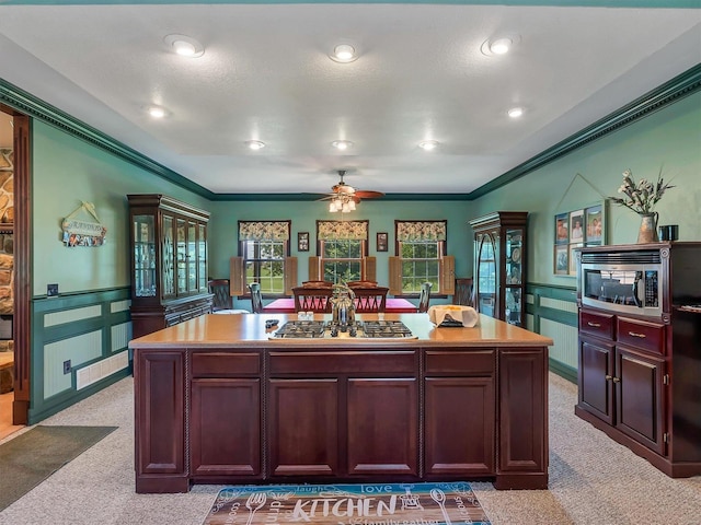 kitchen featuring light carpet, appliances with stainless steel finishes, and a kitchen island