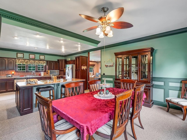 dining room with crown molding, light colored carpet, and sink