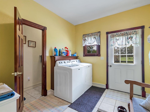 clothes washing area featuring washing machine and dryer and light tile patterned floors