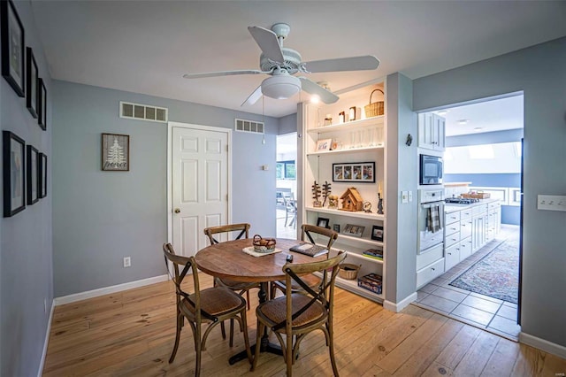 dining room with ceiling fan and light hardwood / wood-style floors