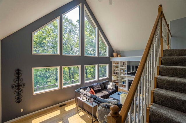 living room featuring vaulted ceiling, plenty of natural light, and light hardwood / wood-style floors