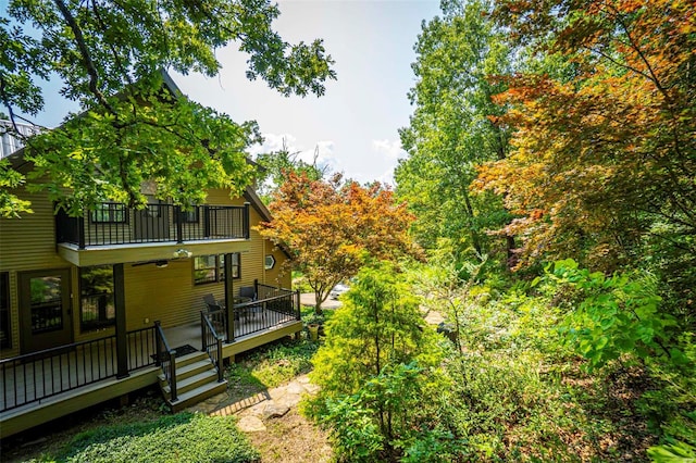 view of yard featuring a balcony and a deck