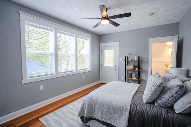 bedroom with ceiling fan, ensuite bathroom, and hardwood / wood-style floors