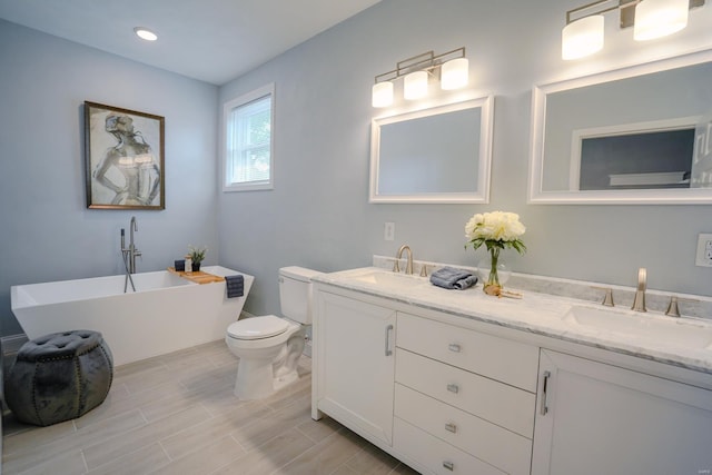 bathroom featuring vanity, toilet, and a tub