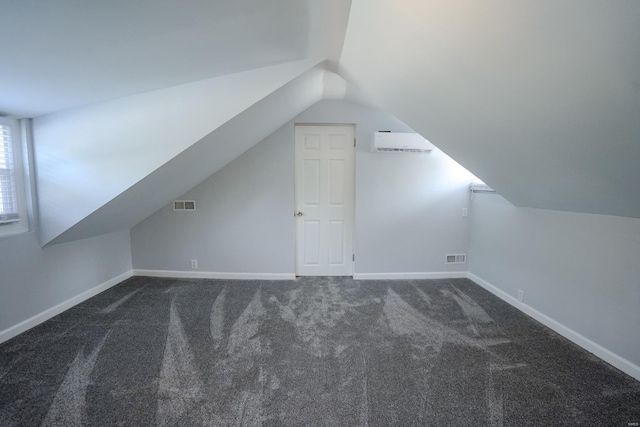 bonus room with vaulted ceiling and dark colored carpet