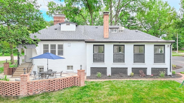 rear view of property with a patio and a lawn