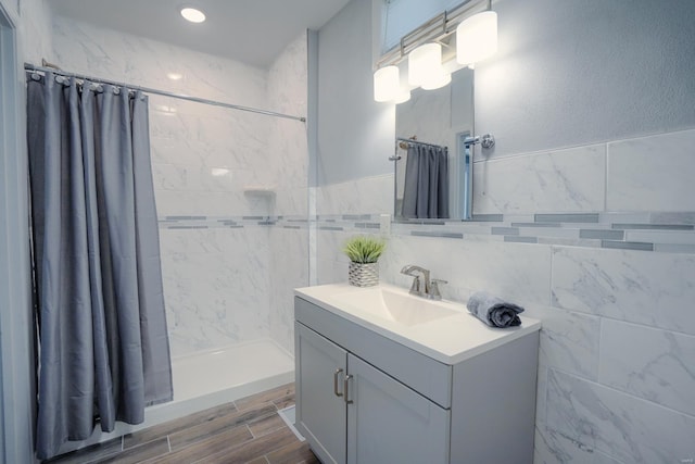 bathroom with vanity, curtained shower, and tile walls