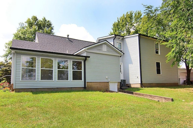 rear view of property featuring a yard and central AC unit