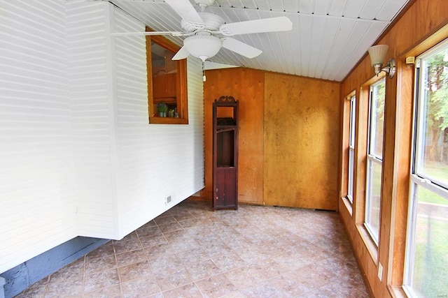 empty room with ceiling fan and wooden walls