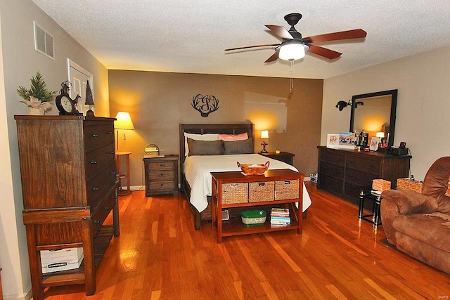 bedroom featuring wood-type flooring, a textured ceiling, and ceiling fan