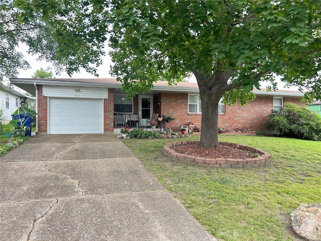 ranch-style home with a garage, a front lawn, and covered porch