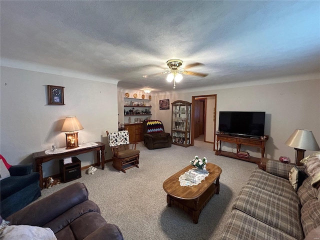 carpeted living room with ceiling fan and a textured ceiling