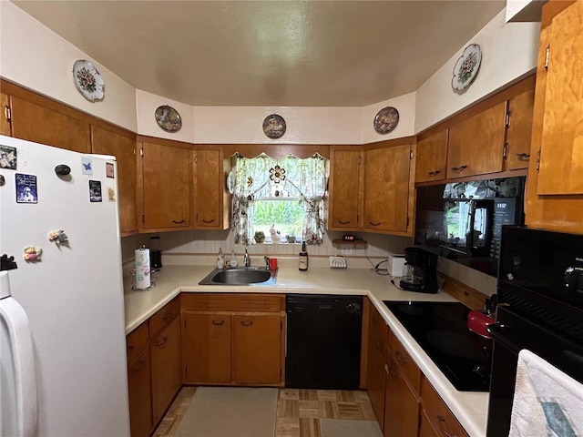 kitchen featuring light parquet flooring, sink, and black appliances