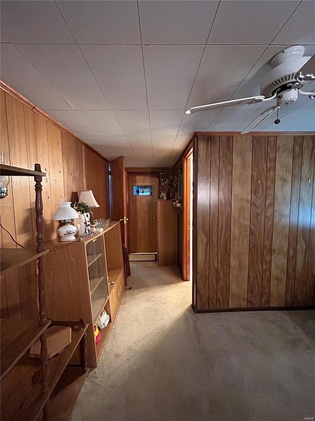 interior space with light carpet and wooden walls