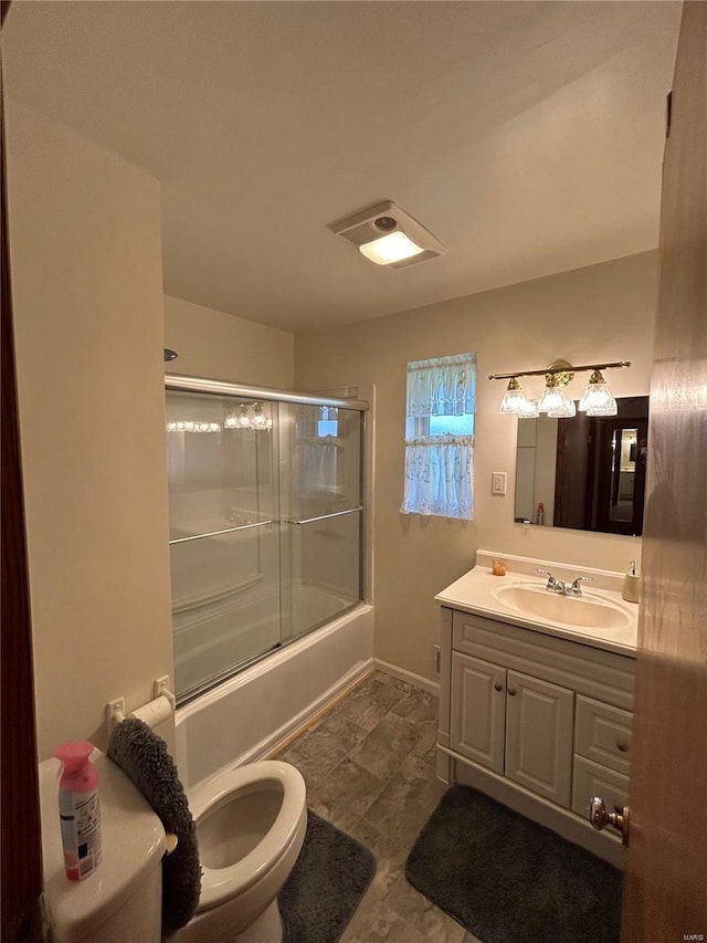 full bathroom featuring toilet, vanity, and shower / bath combination with glass door