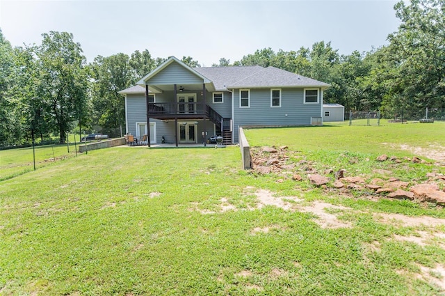 back of property featuring a deck and a lawn