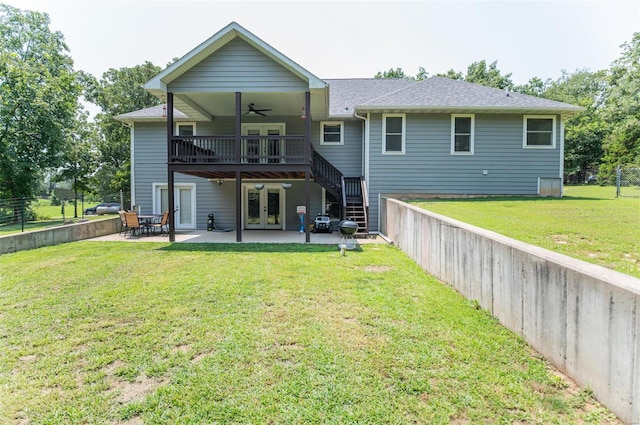 rear view of house featuring a patio, ceiling fan, french doors, and a lawn