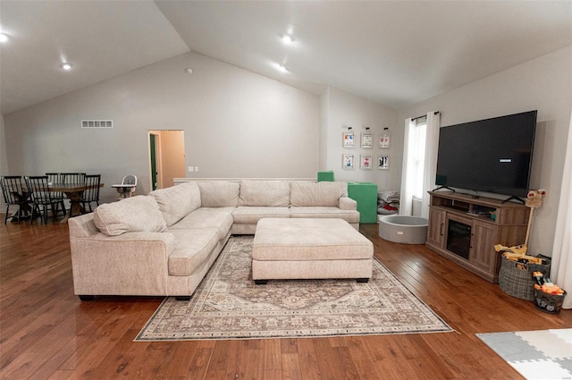 living room featuring dark hardwood / wood-style floors and vaulted ceiling