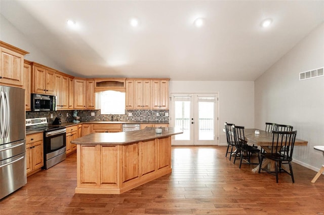 kitchen featuring light wood-type flooring, french doors, stainless steel appliances, and vaulted ceiling