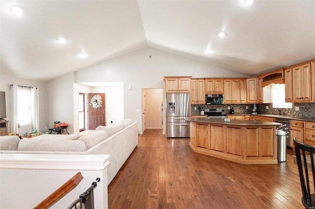 kitchen featuring decorative backsplash, stainless steel appliances, wood-type flooring, and a breakfast bar area