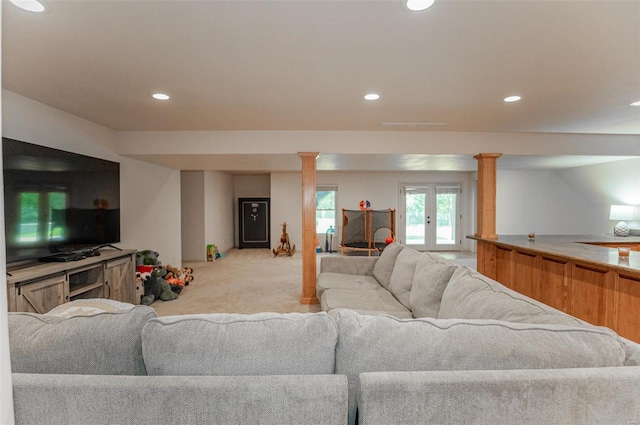 living room with decorative columns, french doors, and light colored carpet