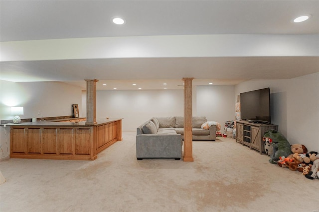 living room featuring decorative columns and light colored carpet