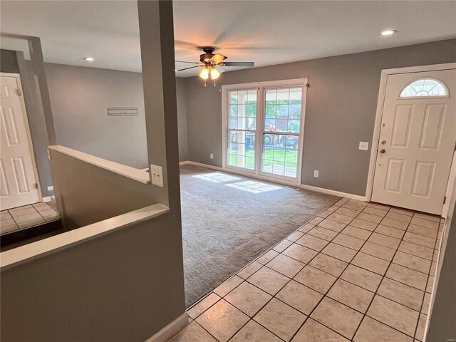 entryway with ceiling fan and light colored carpet