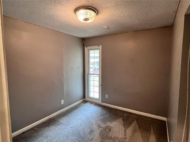 empty room featuring a textured ceiling and carpet flooring