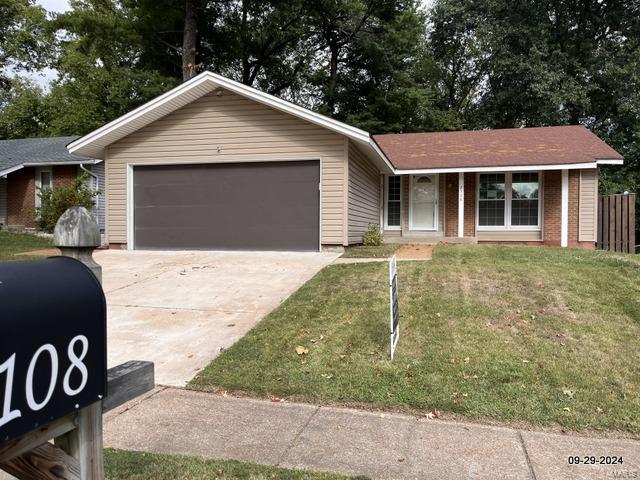 single story home featuring a front lawn and a garage