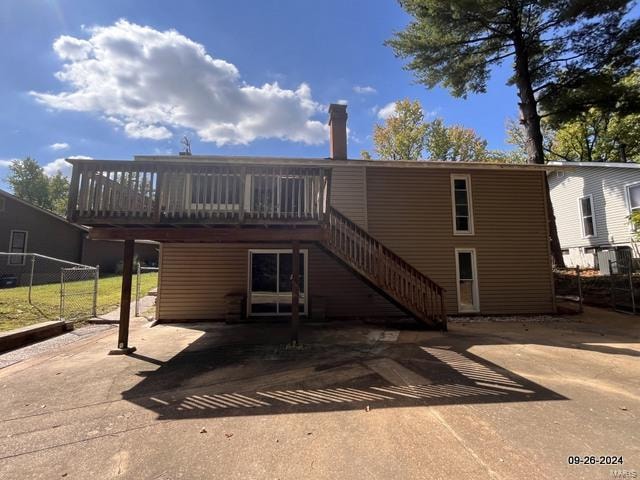 back of property featuring a deck and a patio area