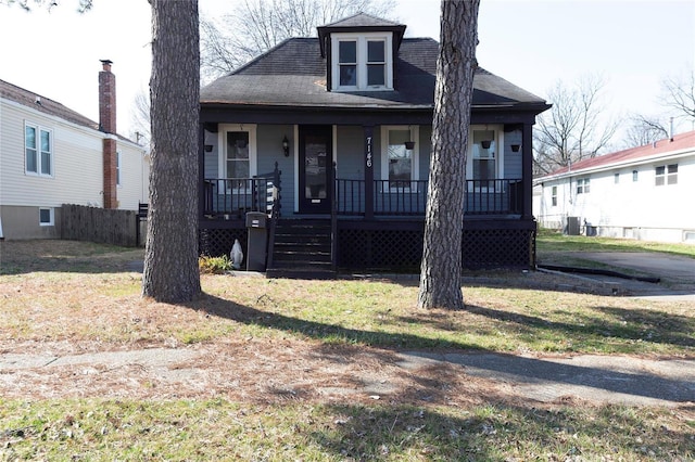 view of front of house featuring central AC unit, covered porch, and a front lawn