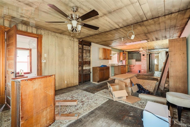 misc room with wooden walls, wood ceiling, and ceiling fan