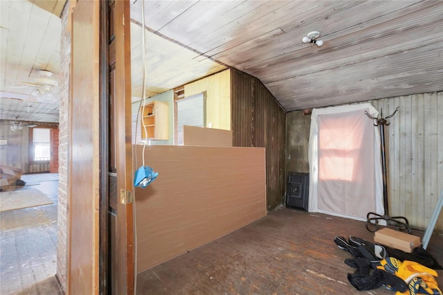 additional living space featuring wood ceiling and wood walls