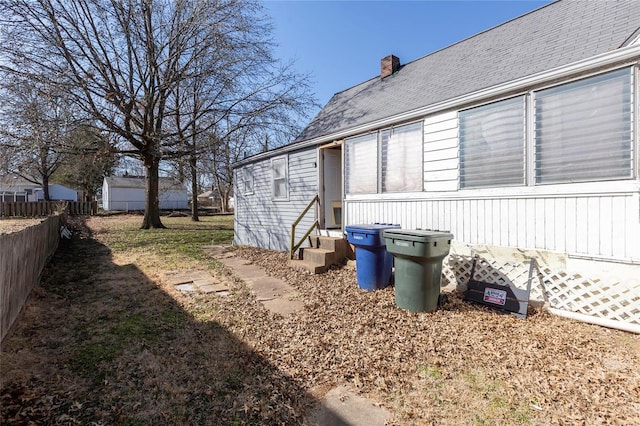 view of yard featuring entry steps and fence