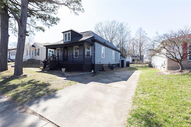 view of front of home with a porch, driveway, and a front lawn