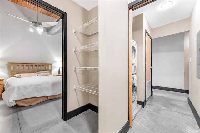 interior space featuring stacked washer and dryer, visible vents, concrete floors, and baseboards