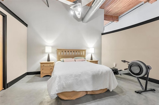 bedroom featuring baseboards and concrete flooring