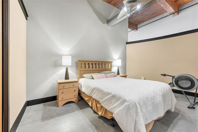 bedroom featuring concrete floors and baseboards