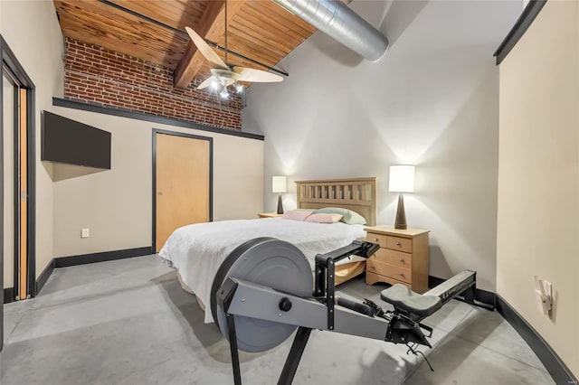 bedroom featuring a closet, concrete floors, baseboards, and ceiling fan