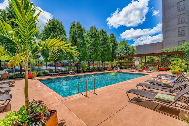 pool with a patio area, a pergola, and fence