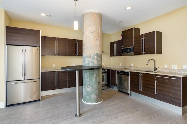 kitchen featuring pendant lighting, sink, light hardwood / wood-style flooring, appliances with stainless steel finishes, and dark brown cabinetry