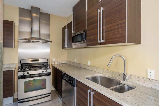 kitchen featuring wall chimney range hood, stainless steel appliances, sink, and light stone countertops