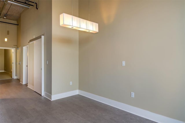 empty room featuring hardwood / wood-style floors and a high ceiling