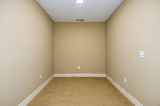 empty room with baseboards, light carpet, and visible vents