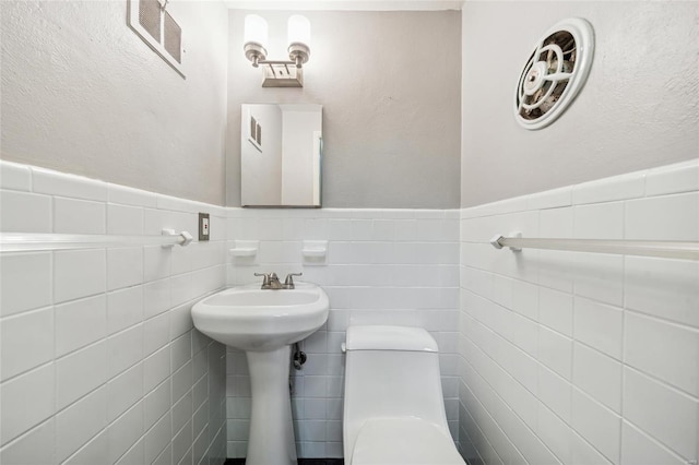 bathroom featuring tile walls, tasteful backsplash, and toilet