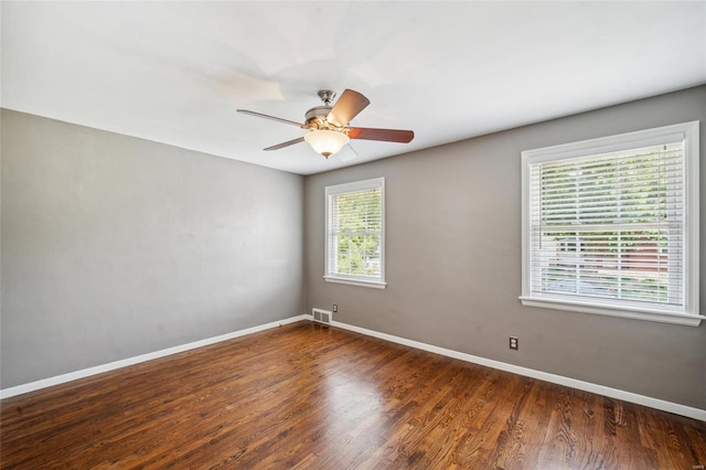 empty room featuring dark wood-type flooring and ceiling fan