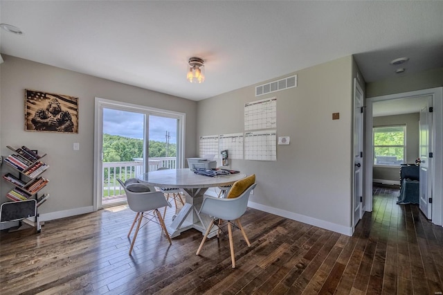 dining room with a wealth of natural light and dark wood-type flooring