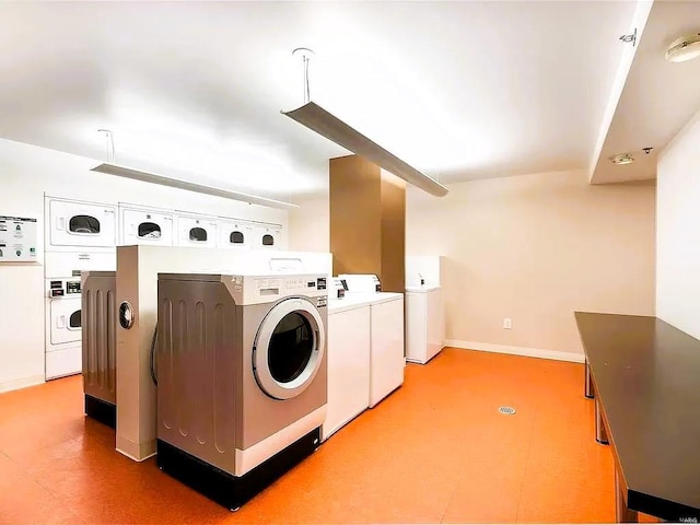 laundry area with washing machine and clothes dryer, stacked washer / drying machine, and tile patterned floors